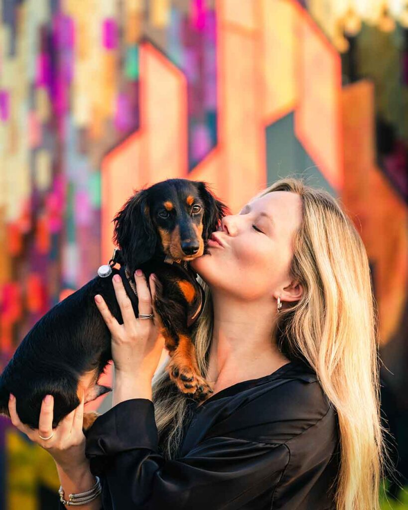 Rehome and Adopt a Small Dog 16 Happy woman kissing her newly adopted small dog, long haired Dachshund, who she has welcomed into her life.